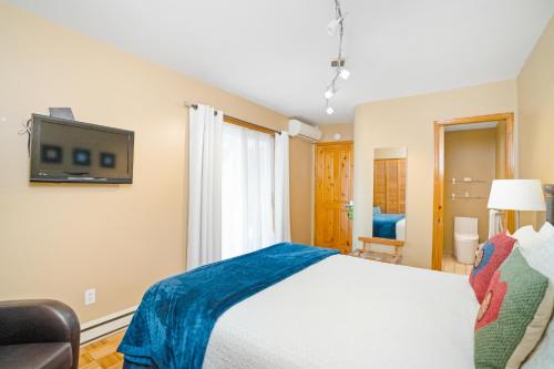 a bedroom with a bed and a tv on the wall at Accueil Chez Francois in Montréal