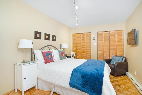 a bedroom with a large bed and a chair at Accueil Chez Francois in Montréal