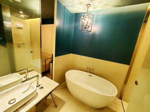 a bathroom with a tub and a sink and a mirror at Le Stendal Hotel in Daejeon