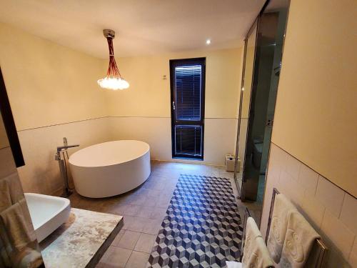 a bathroom with a tub and a toilet and a sink at Le Stendal Hotel in Daejeon
