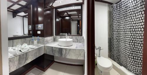 a bathroom with a sink and a toilet and a mirror at HOTEL TESORO BEACH in San Luis La Herradura