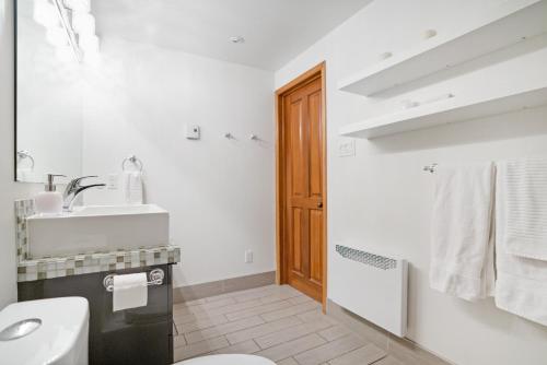 a white bathroom with a sink and a toilet at Accueil Chez Francois in Montréal