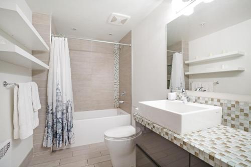 a bathroom with a sink and a tub and a toilet at Accueil Chez Francois in Montréal