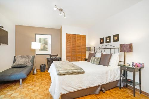 - une chambre avec un grand lit et une chaise dans l'établissement Accueil Chez Francois, à Montréal