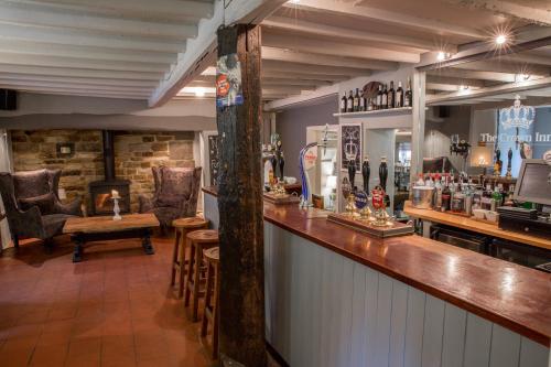 a bar in a pub with a counter and chairs at The Crown Inn in Towcester
