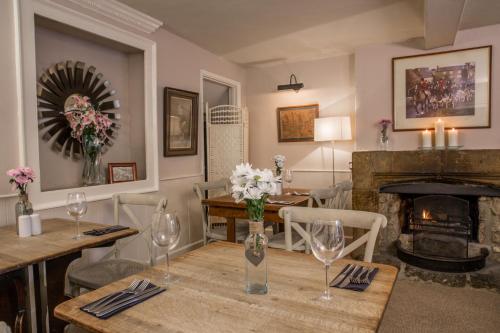 a dining room with a table and a fireplace at The Crown Inn in Towcester