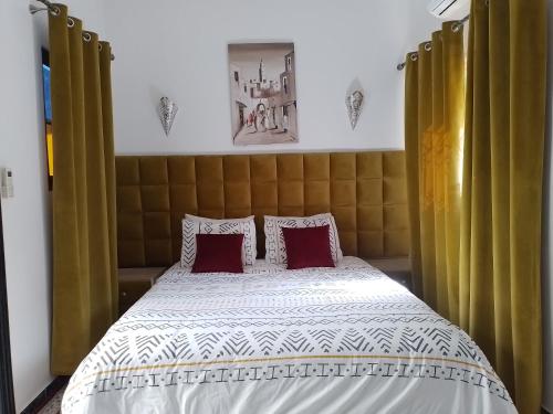 een slaapkamer met een bed met rode kussens bij Un Riad pour se divertir en famille & se détendre in Marrakesh