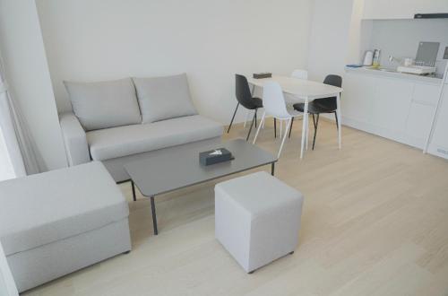 a living room with a couch and a table and chairs at C-One Resort Jaeundo in Sinan
