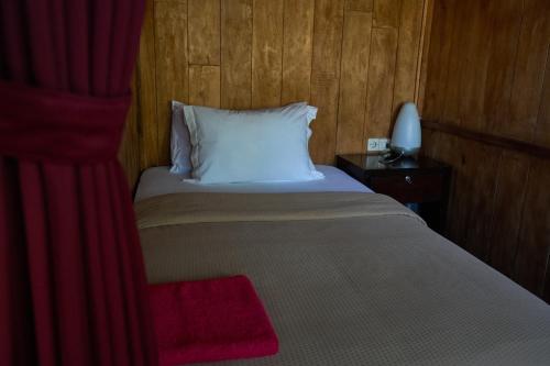 a bedroom with a white bed with a red drape at Chakra Tavern in Bedugul