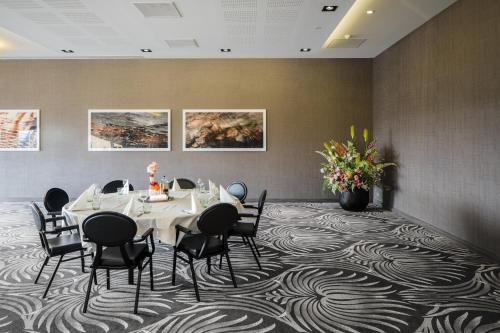a meeting room with a table and chairs on a carpet at Van Der Valk Hotel Zwolle in Zwolle