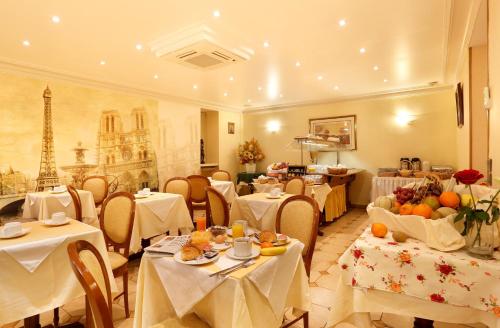 a restaurant with tables and chairs with food on them at Hotel Paix Republique in Paris