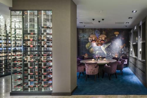 a dining room with a table and a wall of wine bottles at Van Der Valk Hotel Zwolle in Zwolle