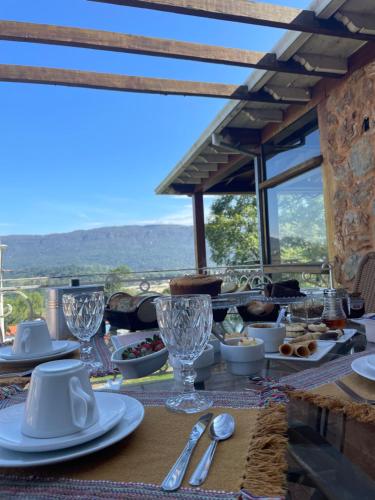 a table with plates of food and glasses on it at Pousada Pedra Pimenta in Tiradentes