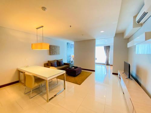 a living room with a table and a couch at HABITARE Rasuna Jakarta in Jakarta