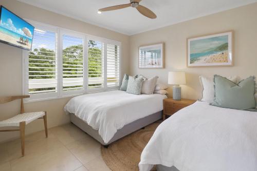 a bedroom with two beds and a window at Serenity on Hastings Street, Noosa Heads in Noosa Heads