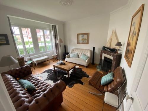 un salon avec des canapés en cuir et une cheminée dans l'établissement Villa calme et spacieuse près de la plage, avec jardin et WIFI à Villers-sur-Mer - FR-1-712-53, à Villers-sur-Mer