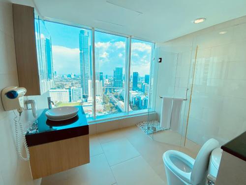 a bathroom with a view of a city skyline at Habitare Apart Hotel Rasuna Jakarta Powered by Archipelago in Jakarta