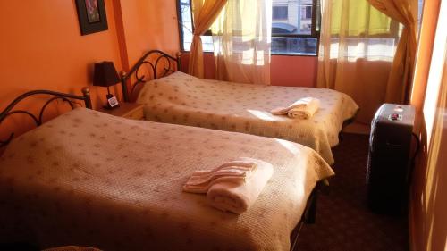 Habitación de hotel con 2 camas y toallas. en Hostal "Oro Blanco", en Uyuni