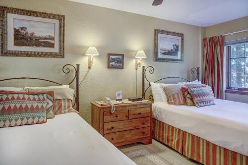 a bedroom with two beds and a wooden dresser at St. James Place in Beaver Creek