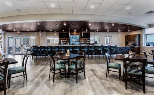 a dining room with tables and chairs and a bar at Holiday Inn Hotel & Suites Daytona Beach On The Ocean by IHG in Daytona Beach