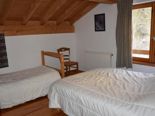 a bedroom with a bed and a chair and a window at Chalet Pralognan-la-Vanoise, 5 pièces, 8 personnes - FR-1-464-176 in Pralognan-la-Vanoise