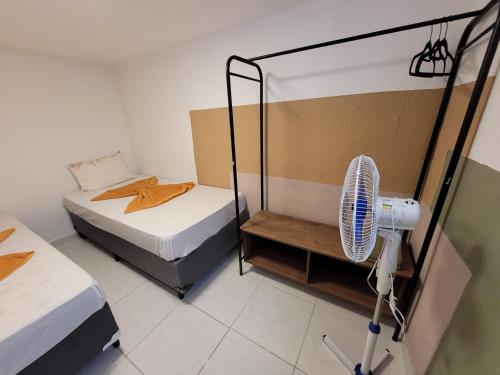 Una habitación con dos camas y un ventilador. en Self Hostel, en São Paulo