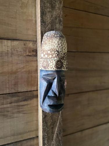a blue mask hanging on a wooden wall at Maiku Amazonas in Puerto Nariño