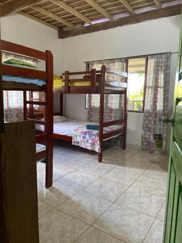 a room with three bunk beds in a house at Maiku Amazonas in Puerto Nariño