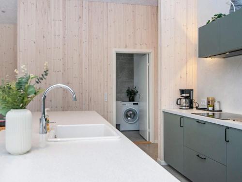 eine Küche mit einer Spüle und einer Waschmaschine in der Unterkunft Holiday home Glesborg XCVII in Glesborg