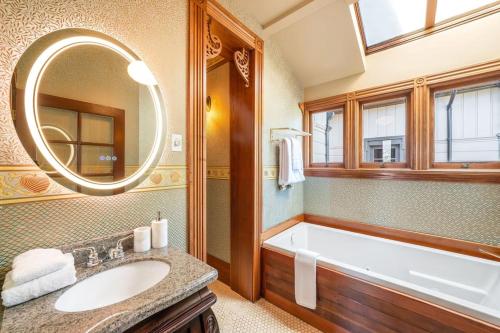 uma casa de banho com uma banheira, um lavatório e um espelho. em Luxurious Wine Country Estate em Geyserville