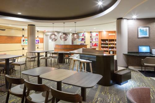 a restaurant with tables and chairs and a library at SpringHill Suites Indianapolis Fishers in Indianapolis