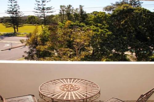a table and chairs with a view of a park at Kundu Lodge - Hosted by Burleigh Letting in Gold Coast