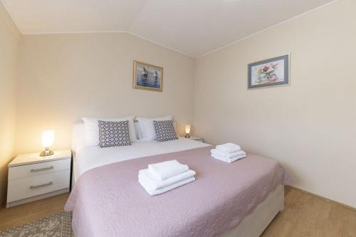 a bedroom with a bed with two towels on it at Apartments Mira in Zadar