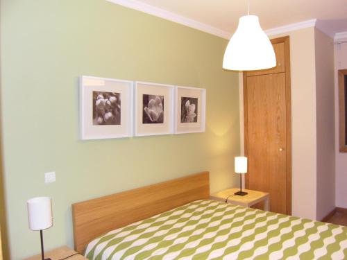 - une chambre avec un lit et trois photos sur le mur dans l'établissement Anadia Chic Apartment, à Funchal