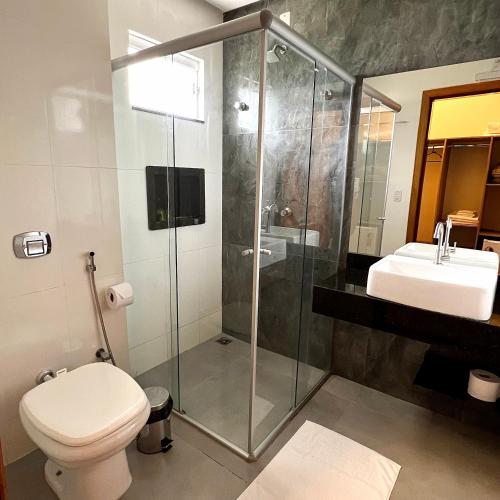a bathroom with a shower and a toilet and a sink at Pousada Piri Paim in Pirenópolis
