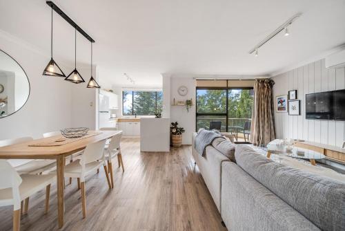 a living room and dining room with a couch and a table at Avalanche 3 - 3BR Apartment l Central Location l Balcony l WiFi in Jindabyne