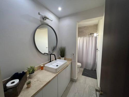 a white bathroom with a sink and a mirror at Consulado Home in Ciudad Juárez