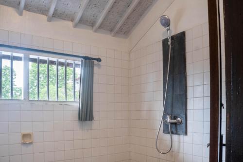 a bathroom with a shower with a shower head at In Da Lodge in Ubud