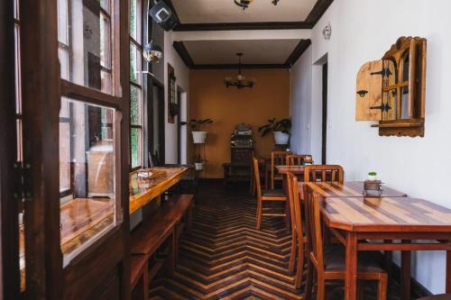 una sala da pranzo con tavoli e sedie in legno di La Culta hostal & centro cultural a Sucre