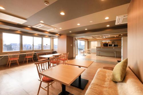 a living room with a couch and a table and chairs at Asakusa Hotel Hatago in Tokyo