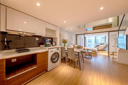 een keuken en een woonkamer met een wasmachine. bij Roy Chen Apartment in Tongzhou District in Beijing