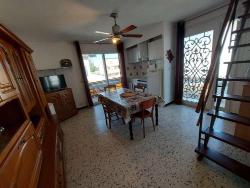 un salon avec une table et une cuisine dans l'établissement Appartement 3 Pièces Climatisé pour 6 Personnes avec Terrasse et Cuisine Équipée à Marseillan - FR-1-326-786, à Marseillan