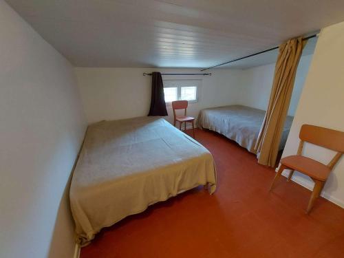 une petite chambre avec deux lits et une fenêtre dans l'établissement Appartement 3 Pièces Climatisé pour 6 Personnes avec Terrasse et Cuisine Équipée à Marseillan - FR-1-326-786, à Marseillan