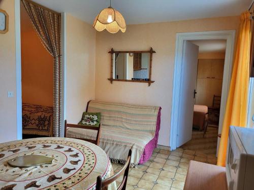 un salon avec une table et une chaise dans l'établissement Appartement cosy 4 pers, jardin privé, accès direct plage, proche commerces, parking inclus - FR-1-465-95, à Merville-Franceville-Plage