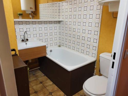 een badkamer met een bad, een toilet en een wastafel bij Appartement Merville-Franceville-Plage, 3 pièces, 4 personnes - FR-1-465-95 in Merville-Franceville-Plage