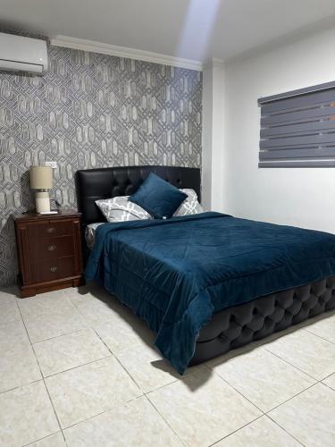 1 dormitorio con 1 cama con edredón azul en Veranda Apartment, Entre Rios, Samborondon, Ecuador, en Guayaquil