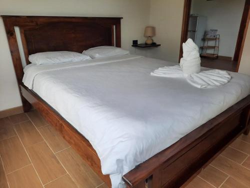 Elle comprend un grand lit avec des draps et des oreillers blancs. dans l'établissement Essence Arenal Spa & Yoga, à La Fortuna