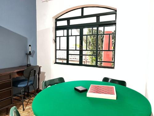 a room with a green table and a window at Chácara em Lindóia no coração do circuito das águas in Lindóia