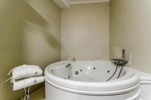 baño blanco con bañera y aseo en Hotel Princess, en Ourense