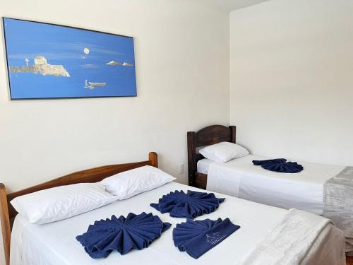 two beds in a room with blue towels on them at Chácara em Lindóia no coração do circuito das águas in Lindóia